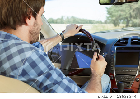 Young man using tablet while sitting in the car Young man using tablet while sitting in the car 18653544