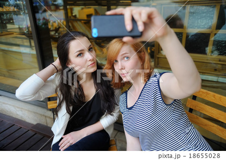 Two young girls taking selfie 18655028