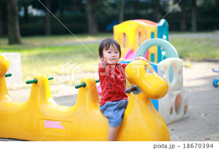 公園の遊具で遊ぶ2歳の男の子の写真素材