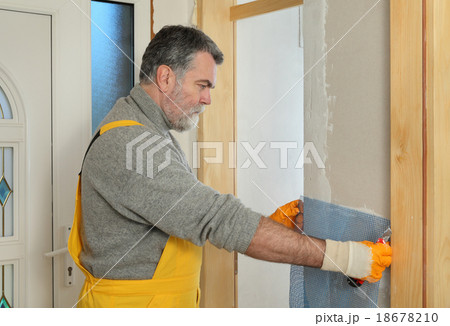 Construction site, worker installing gypsum board 18678210
