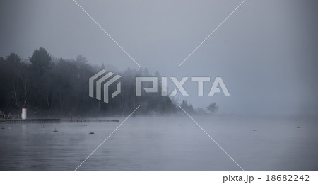 Forest and water in heavy fog rising from Ottawa R 18682242
