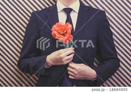 赤いバラの花を持っているビジネスマン 18684005