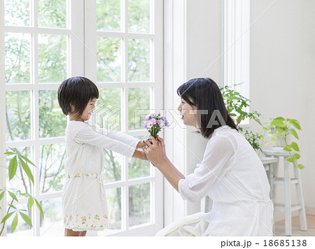 母親に花を差し出す女の子の写真素材