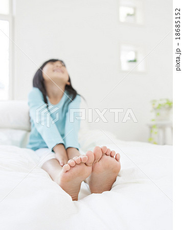 足を伸ばして上を見る女の子の写真素材