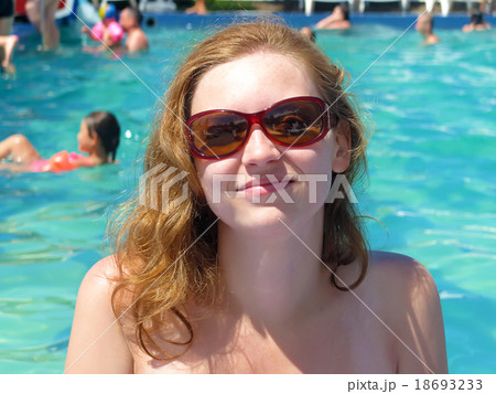 Smiling blond woman by the pool 18693233