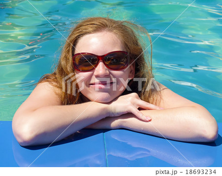 Happy blond woman by the pool Happy blond woman by the pool 18693234