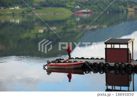 fisherman on a pier on a fjord 18693850