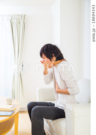 吐き気　嘔吐	気持ち悪い　吐く　体調不良　10代か20代の若い男性　ポートレート　部屋着 18694343
