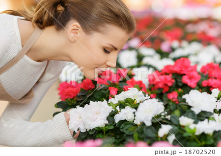 Charming florist smelling flowers Charming florist smelling flowers 18702520