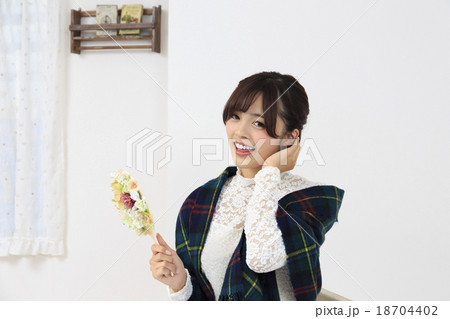 若い女性 手鏡をもち部屋でくつろぐ女性 若い女性 手鏡をもち部屋でくつろぐ女性 18704402