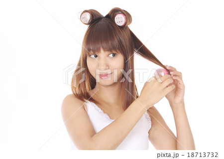 ヘアカーラーで髪を巻く女性 18713732
