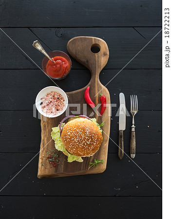 Fresh homemade burger on dark serving board with 18722213