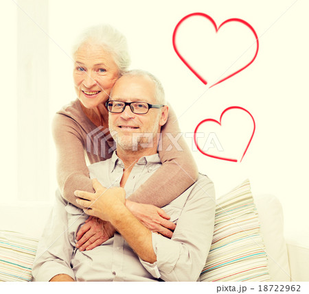 happy senior couple hugging on sofa at home 18722962