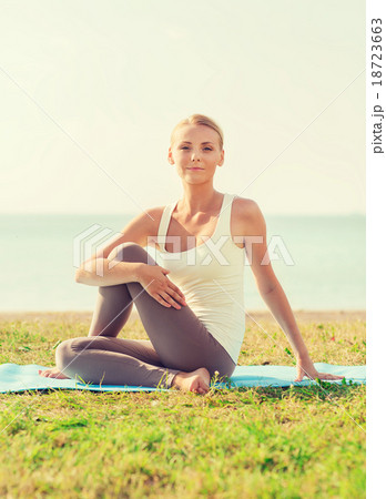 young woman making yoga exercises outdoors 18723663