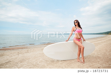 smiling young woman with surfboard on beach 18723731
