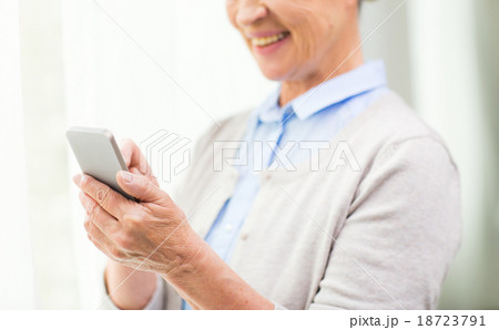 close up of senior woman with smartphone texting 18723791