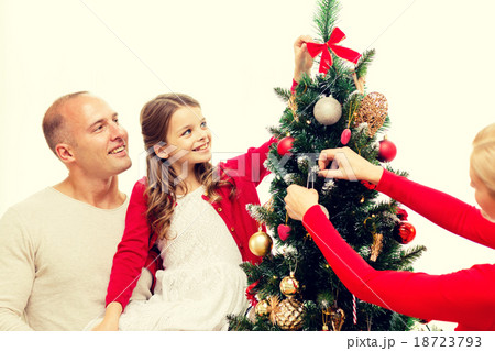 smiling family decorating christmas tree at home 18723793