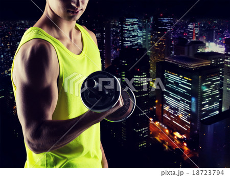 close up of young man with dumbbell flexing biceps 18723794