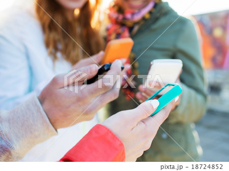 close up of friends with smartphones outdoors close up of friends with smartphones outdoors 18724852