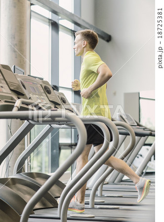 smiling man exercising on treadmill in gym smiling man exercising on treadmill in gym 18725381