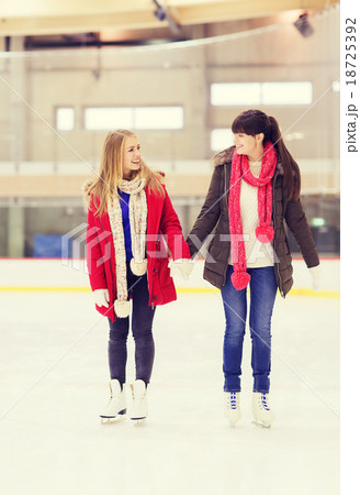 happy girls friends on skating rink 18725392