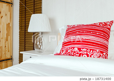 Red pillow on bedroom with white bed sheet  18731400