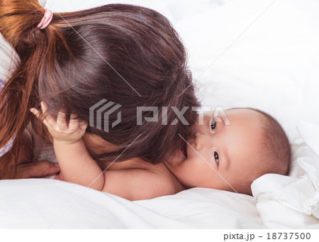 young asian mother and baby in white bed isolated young asian mother and baby in white bed isolated 18737500