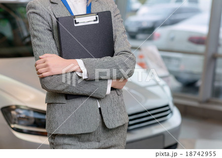 Saleswoman with clipboard is standing beside the Saleswoman with clipboard is standing beside the 18742955