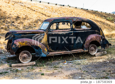 Old rusted car in junk yard 18758369