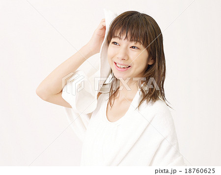 お風呂上がりに髪を拭く女性の写真素材