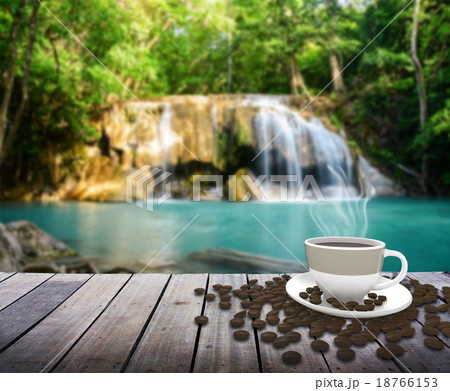 Cup with coffee on table over waterfall Cup with coffee on table over waterfall 18766153