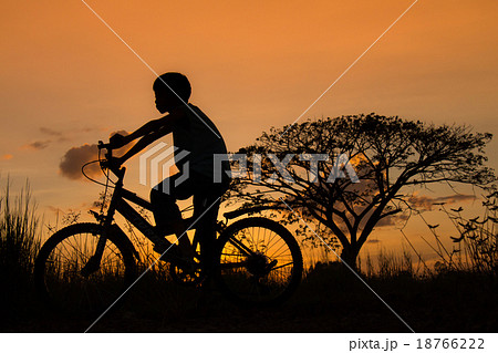 Silhouette of a children and bicycle on sunset 18766222