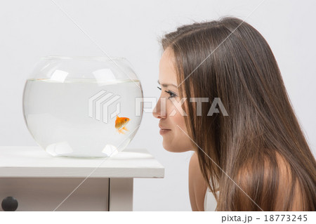 Young girl leaning face to aquarium and looking 18773245