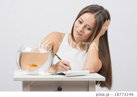 Girl writing notebook desire to fulfill a goldfish 18773246