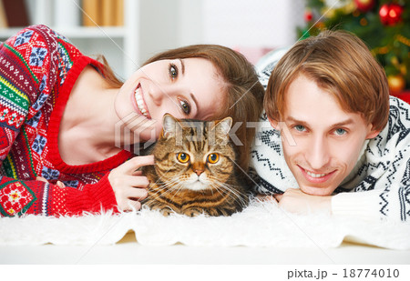 Happy family couple and a cat in Christmas at home Happy family couple and a cat in Christmas at home 18774010