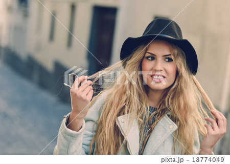 Woman looking with her curly blonde hair in urban background 18774049