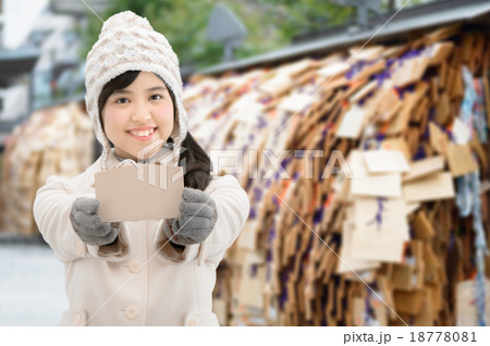 神社で絵馬を持っているコート姿の女性 神社で絵馬を持っているコート姿の女性 18778081
