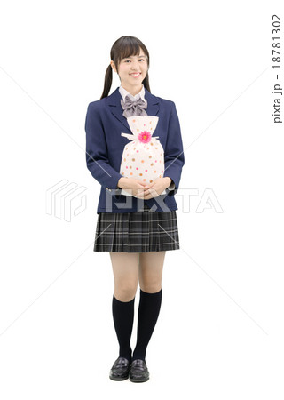 制服を着てプレゼントを持ってポーズしている女子高生の全身白バックのイメージ 18781302