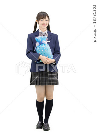 制服を着てプレゼントを持ってポーズしている女子高生の全身白バックのイメージ 18781303
