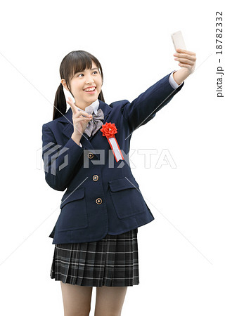 自撮りしている制服を着ている女子高生の白バックイメージの写真素材