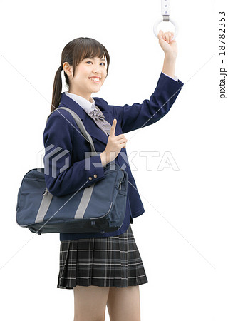 制服を着ている女子高生の電車通学の白バックイメージの写真素材