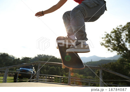 skateboarder legs doing a ollie at skatepark 18784087