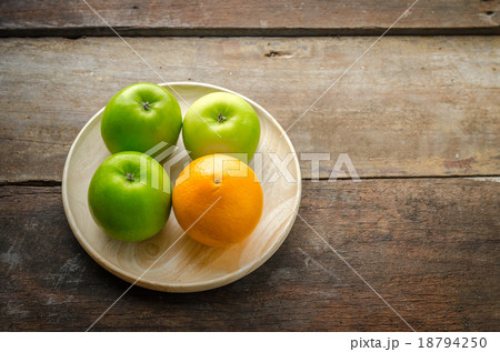 Top view of green apples and orange on wood panel 18794250