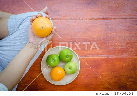 Close up pregnant belly holding oranges in hand 18794251