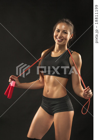 Muscular young woman athlete with a skipping rope 18811199