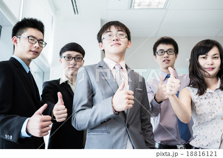 Business team holding their thumbs up Business team holding their thumbs up 18816121