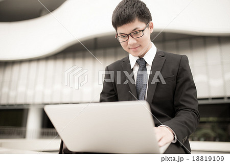 Portrait of a handsome young man on laptop outdoors 18819109