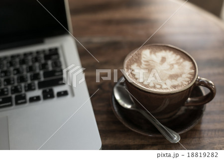 Hot latte coffee cup in cup on a table laptob in coffee shop. 18819282