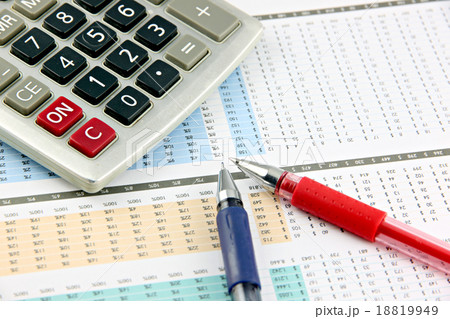 Pen and Calculator that is placed on businesses graph. 18819949