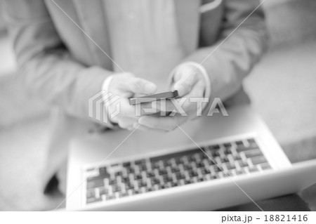 Businessman using laptop pc and mobile phone. He is sitting on a Businessman using laptop pc and mobile phone. He is sitting on a 18821416